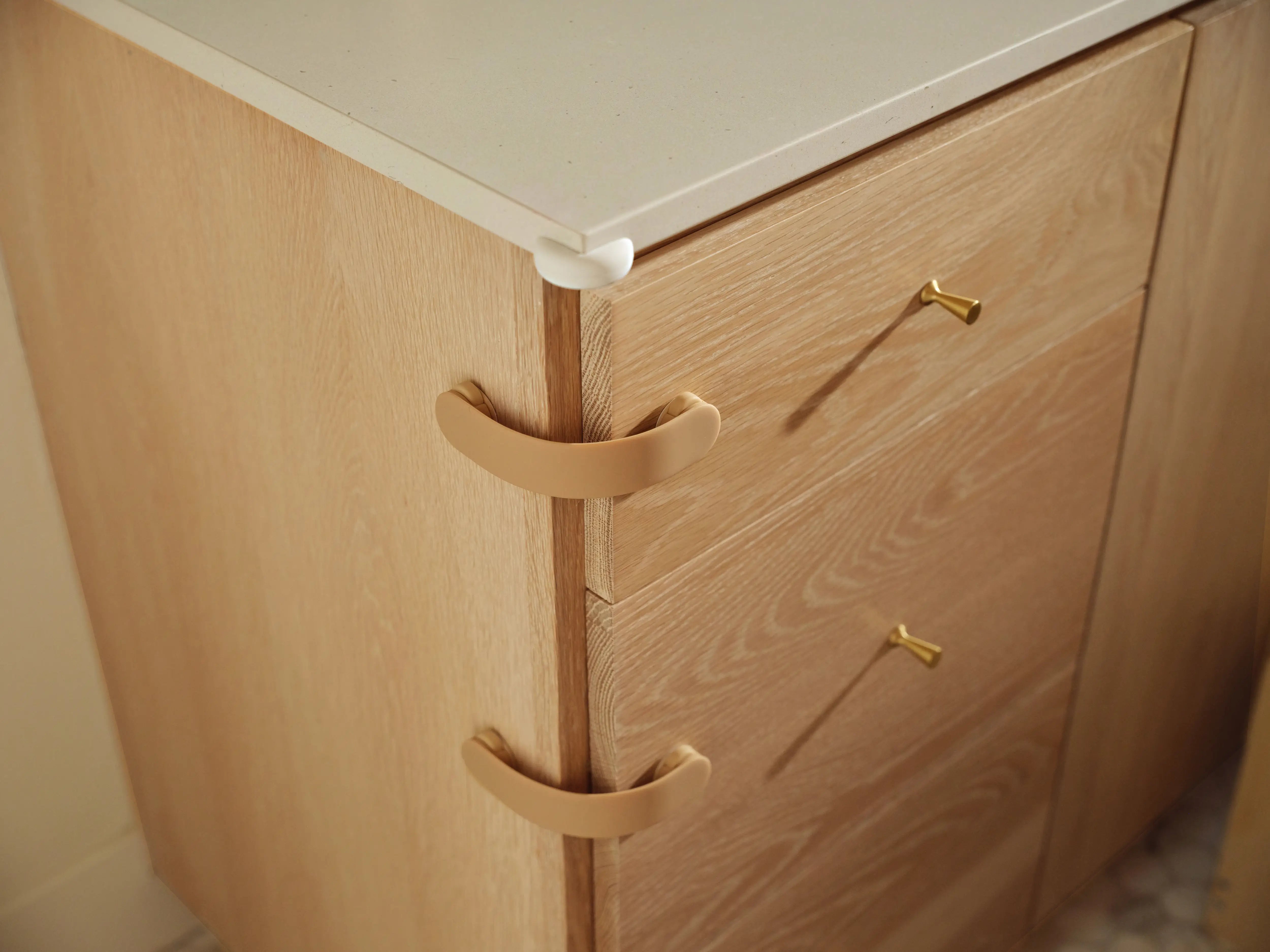 Pom Corner Protector — soft silicone babyproofing guard for sharp furniture corners on the bathroom counter