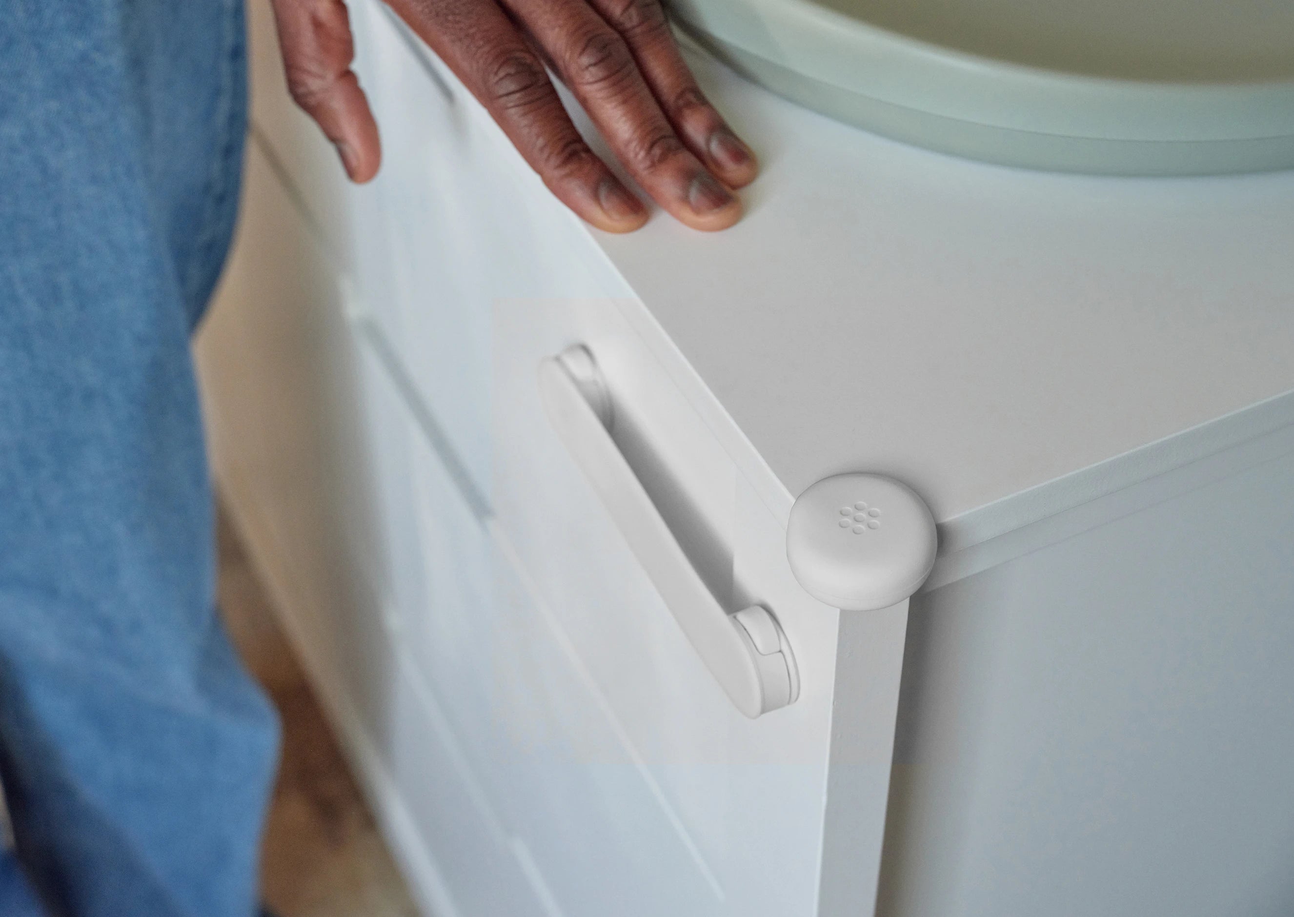 Pom Corner Protector — soft silicone babyproofing guard for sharp furniture corners on a white dresser