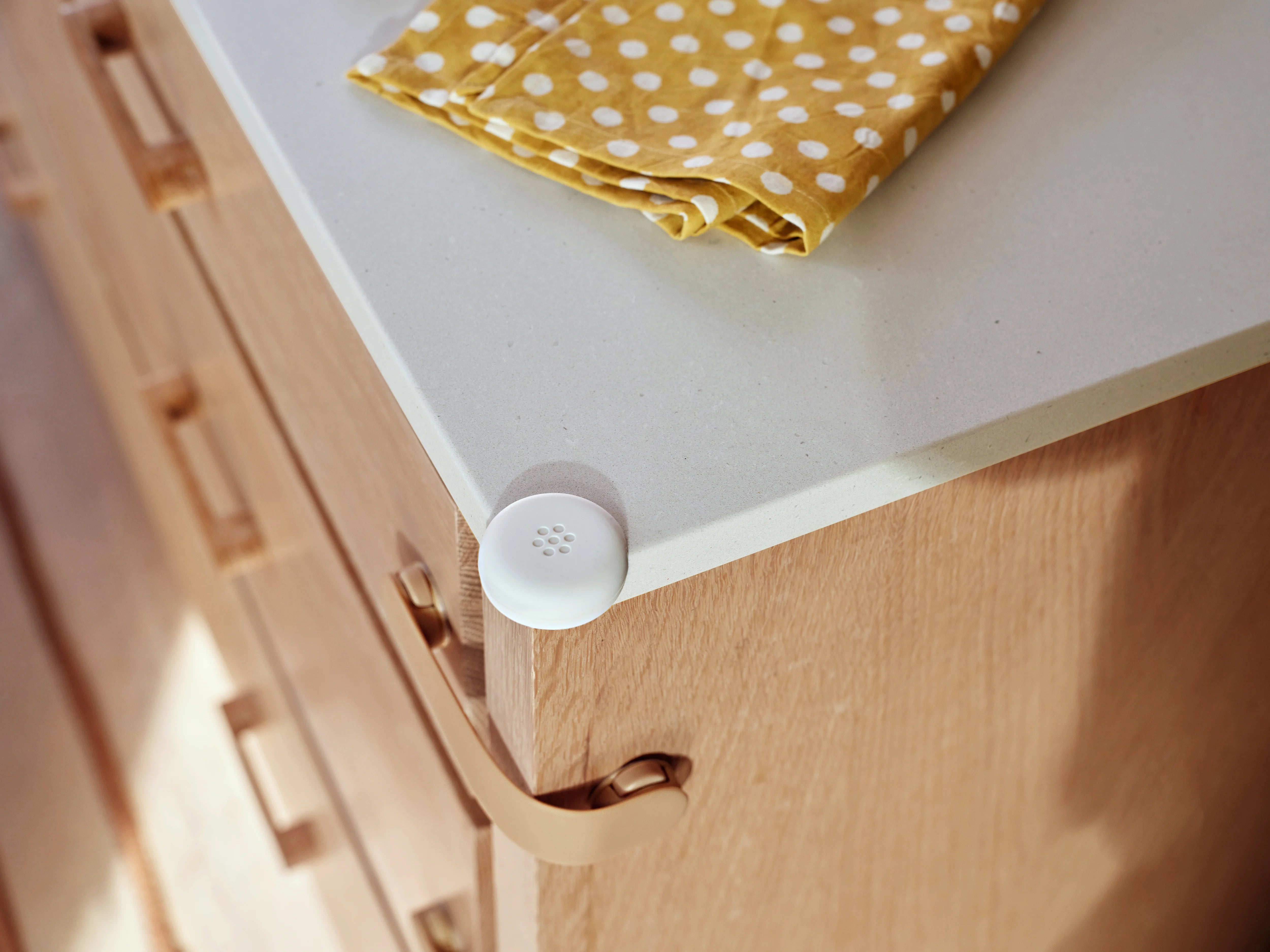 Pom Corner Protector — soft silicone babyproofing guard for sharp furniture corners in the kitchen