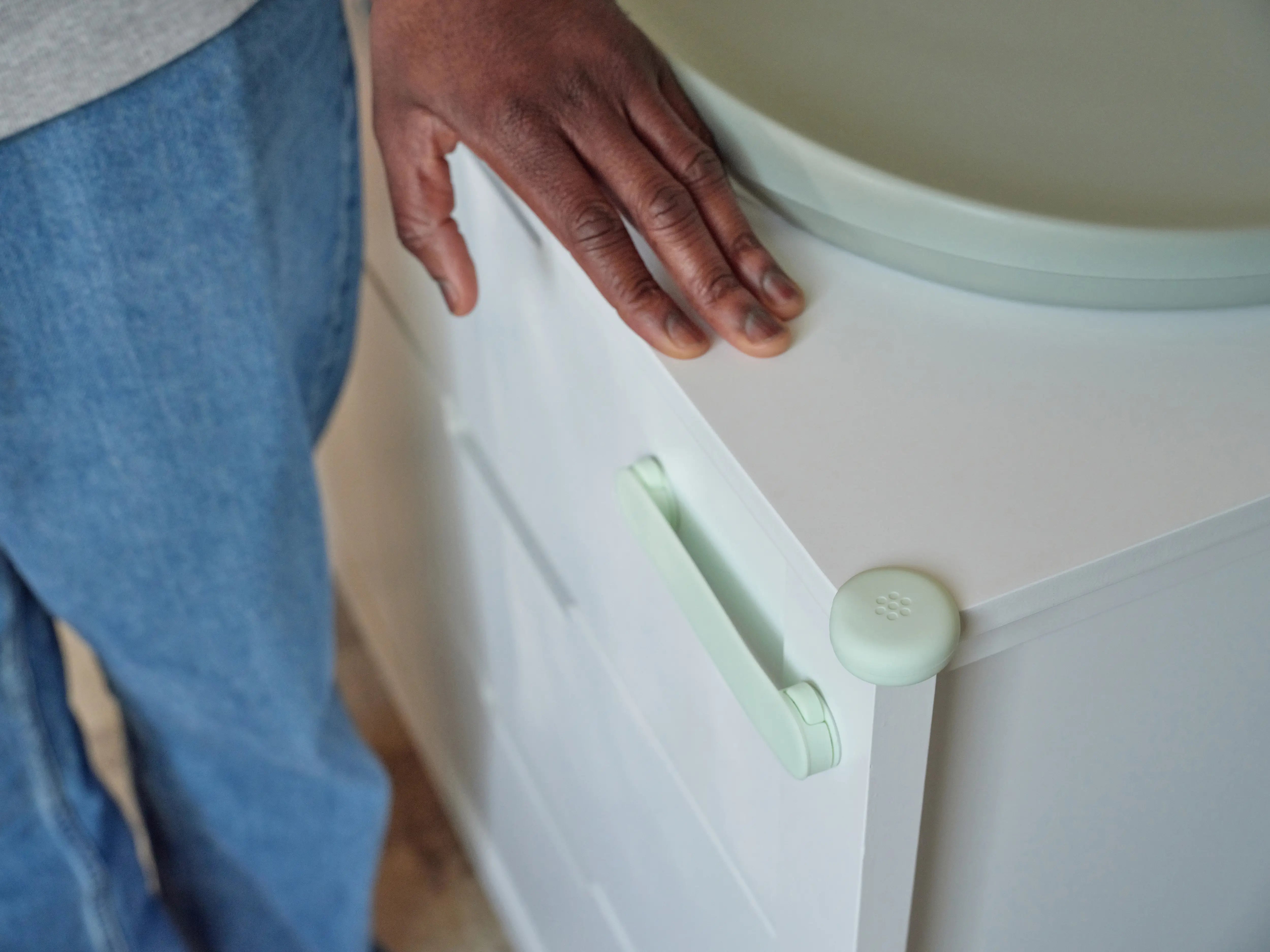Pom Corner Protector — soft silicone babyproofing guard for sharp furniture corners in aloe on a dresser in a babies room