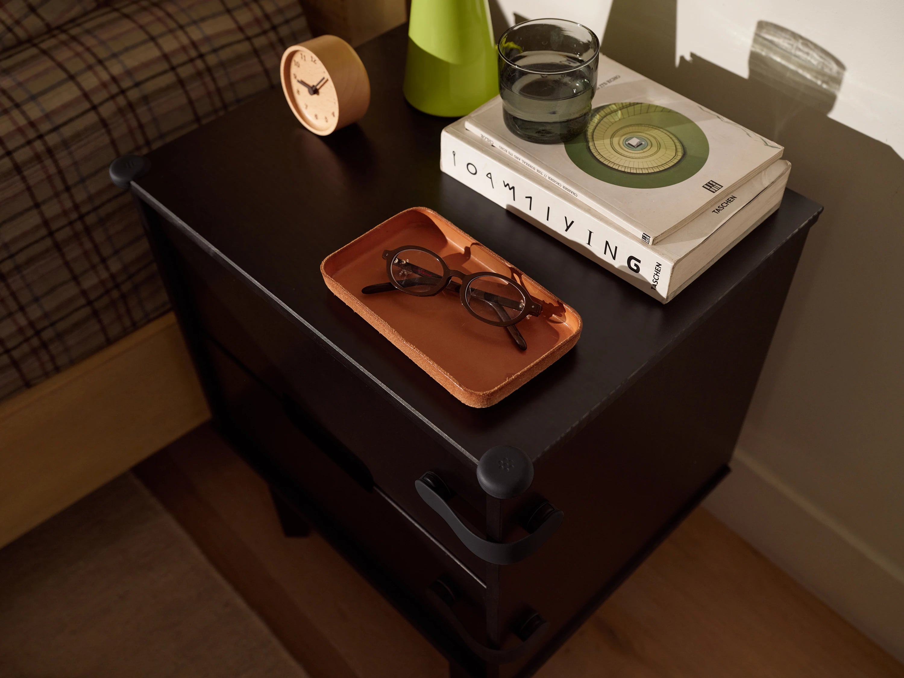 Pom Corner Protector — soft silicone babyproofing guard for sharp furniture corners in black on a bedside table in the bedroom