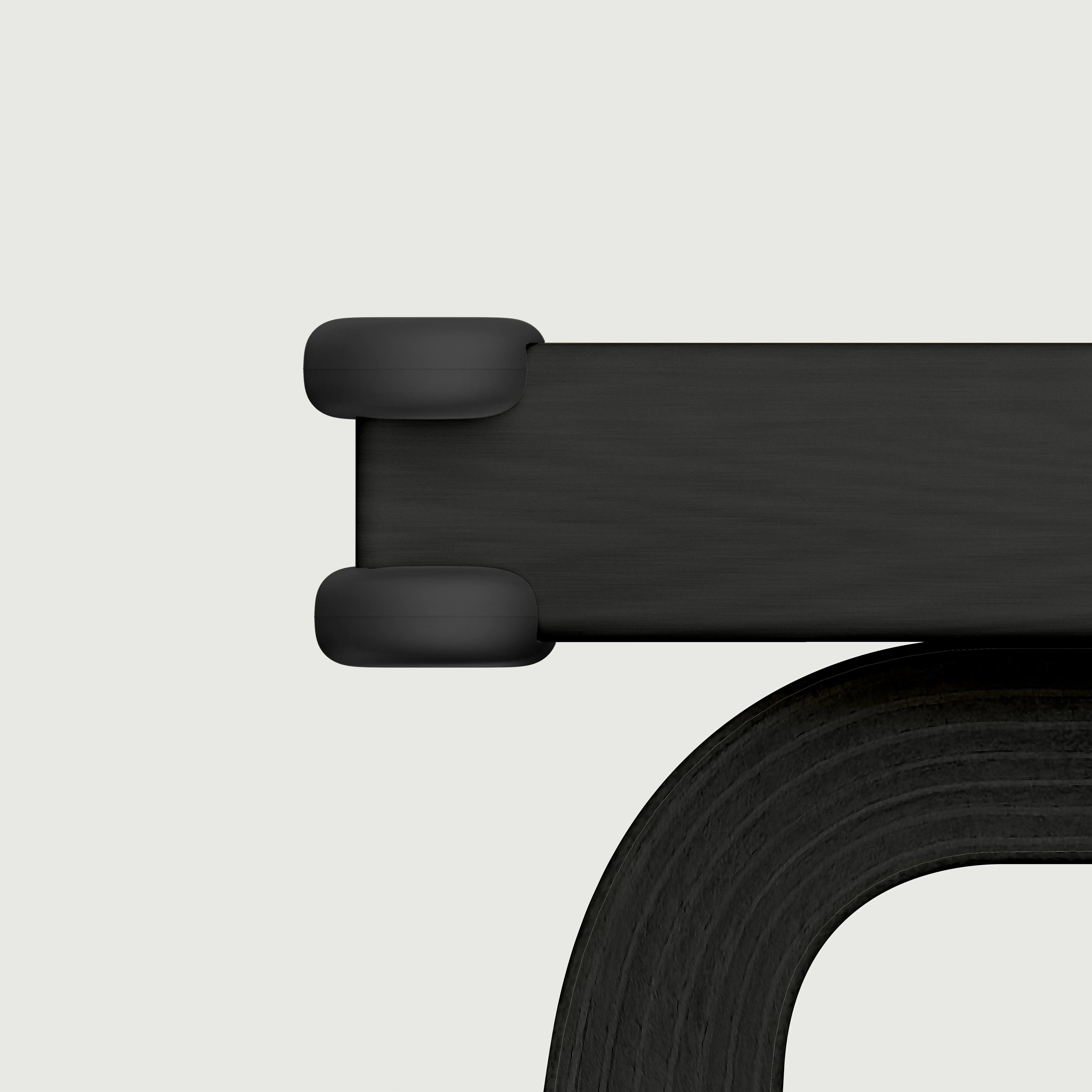 Pom Corner Protector — soft silicone babyproofing guard for sharp furniture corners in black on a dining table